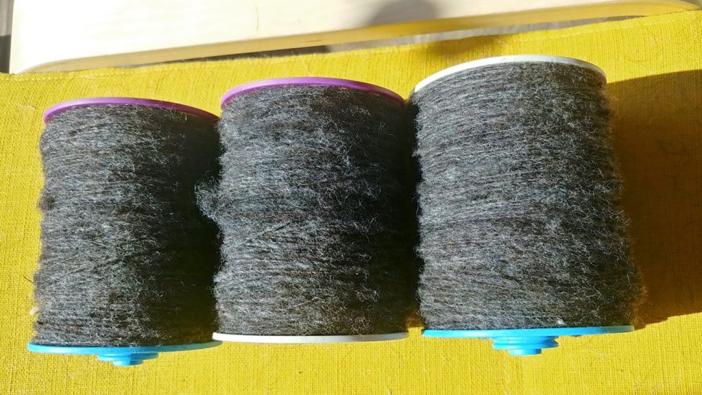 3 yarn bobbins with freshly spun thread