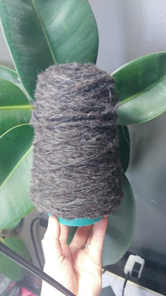 a cheviot spun yarn on a cone held for camera